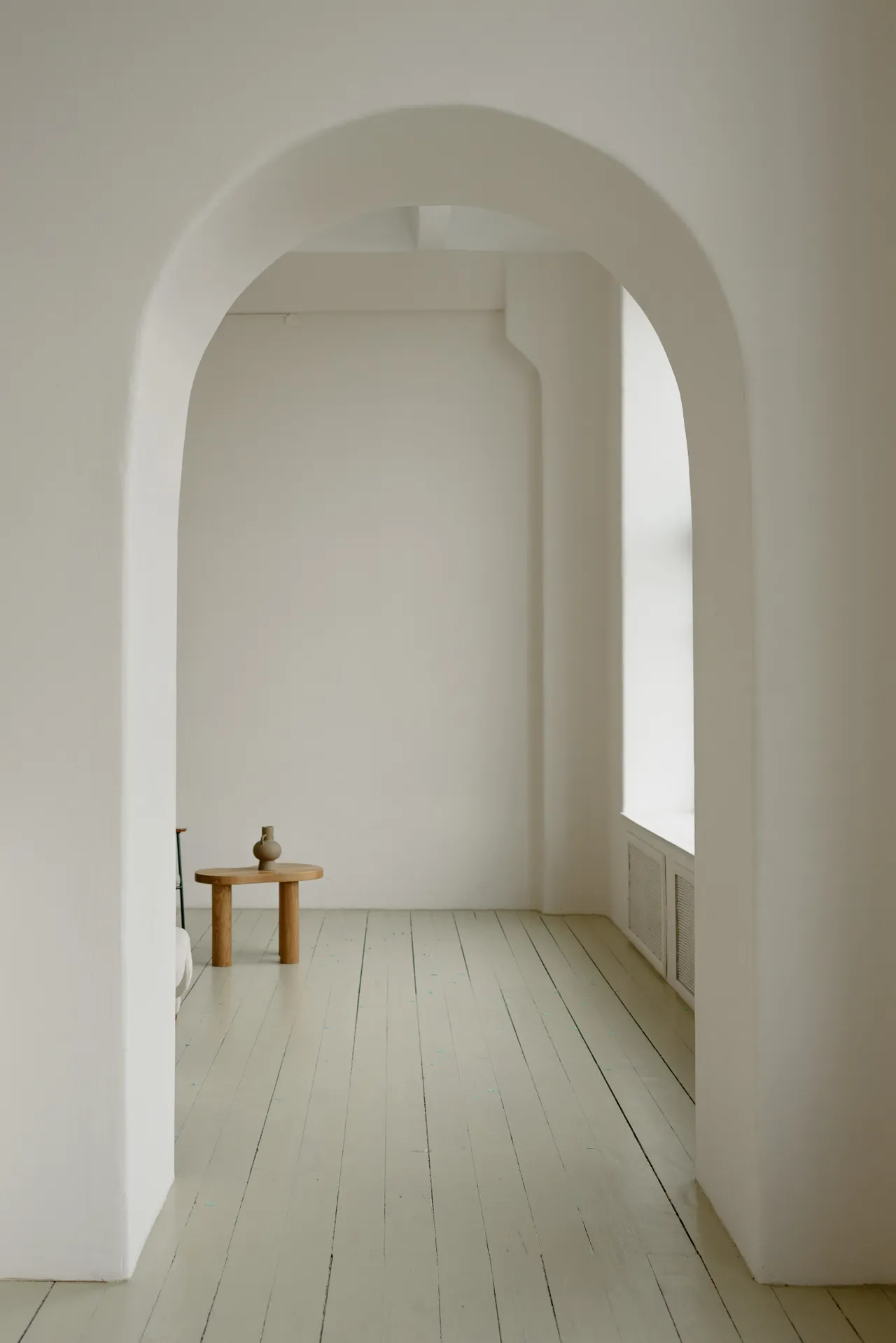 Un arco blanco conecta dos espacios llenos de luz natural